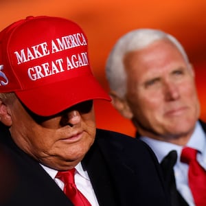 Donald Trump exits a stage with his head down with Mike Pence behind him.