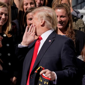 Donald Trump whispers to Maryland women’s lacrosse team members as he greets members of Championship NCAA teams at the White House in Washington, D.C., Nov. 17, 2017.  