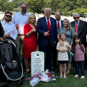 Donald Trump was photographed smiling and giving an awkward thumbs up Monday at the graves of fallen Marines in Arlington National Cemetery.