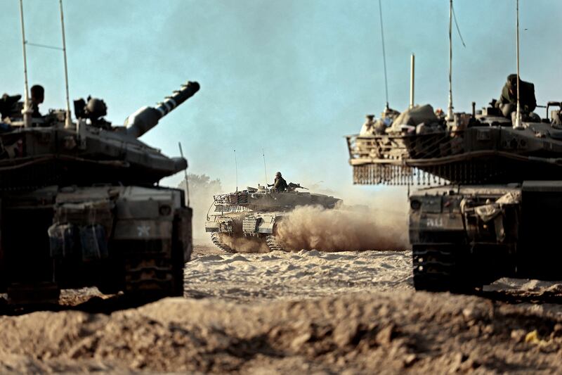 Israeli tanks gather in a field near the kibbutz Be’eri in southern Israel on Oct. 14, 2023.