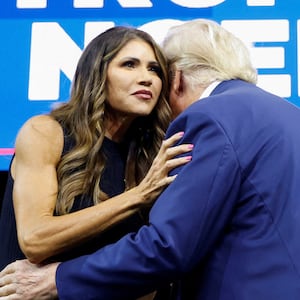 Donald Trump hugs Kristi Noem as he takes the stage in 2023. 