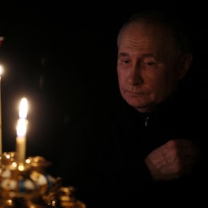 Russian President Vladimir Putin lights a candle.