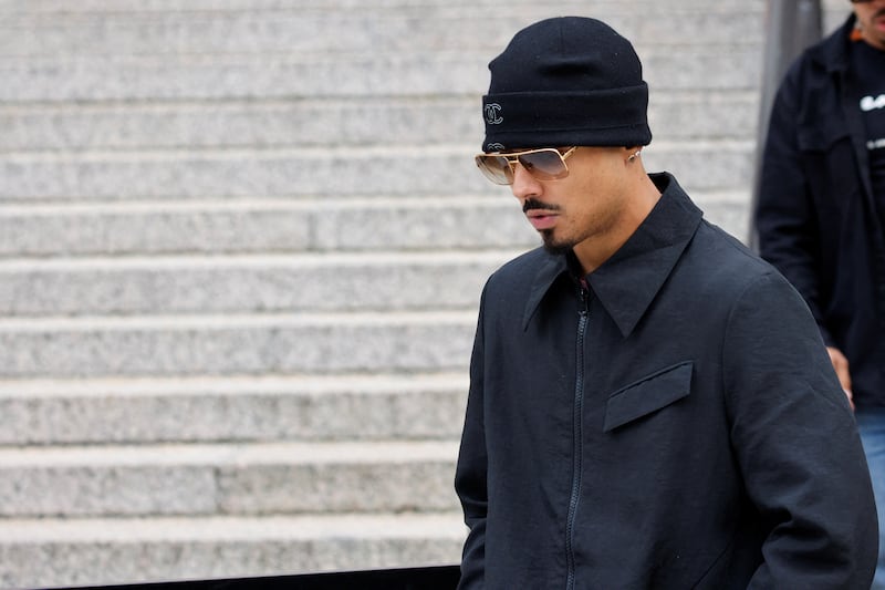 Quincy Brown, wearing a beanie and sunglasses, walks outside a courthouse