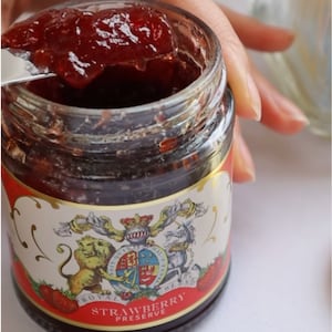 Side-by-side photos of Buckingham Palace’s strawberry jam advertisement.