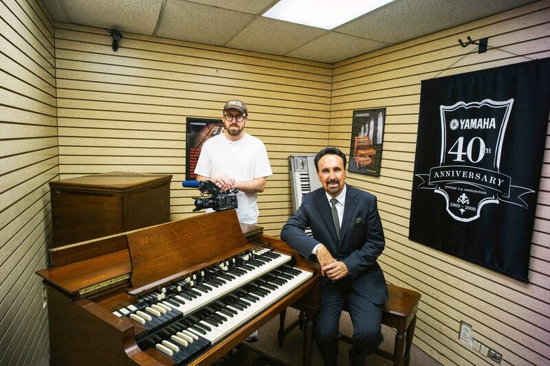 A still from the season finale of How To With John Wilson showing John Wilson and a person with an organ.