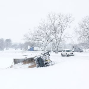 A semi-truck is seen toppled over on the side of a road amidst a snowstorm on January 09, 2024 in Des Moines, Iowa.