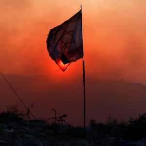 Distressed Israeli flag with red haze in the background