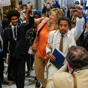 Tennessee State Representative Justin Pearson, Gloria Johnson and Justin Jones hold hands as they walk in the State House.