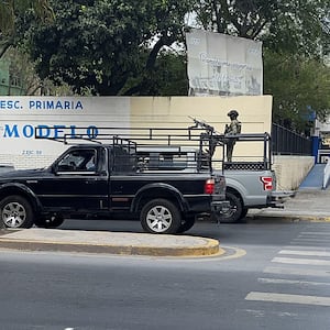 A man with a machine gun in the back of a truck