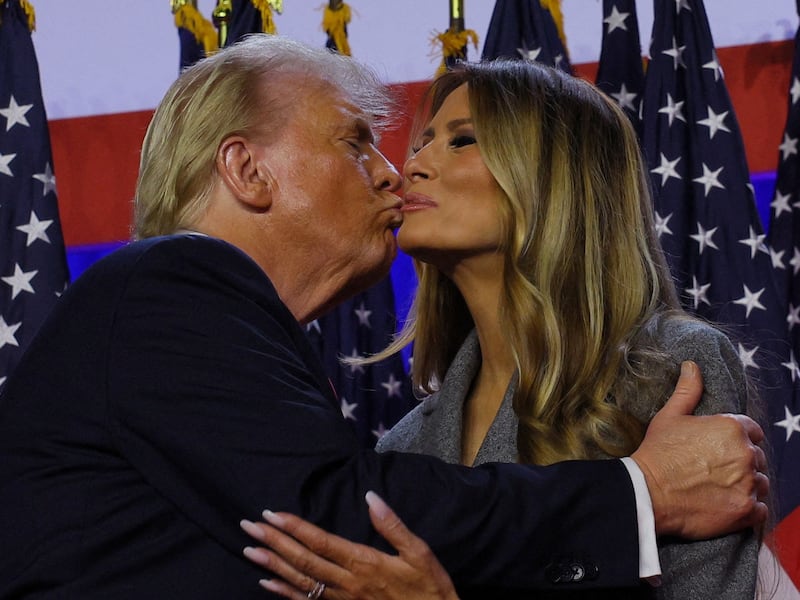 Donald Trump (left) kisses the cheek of his wife Melania Trump (right)