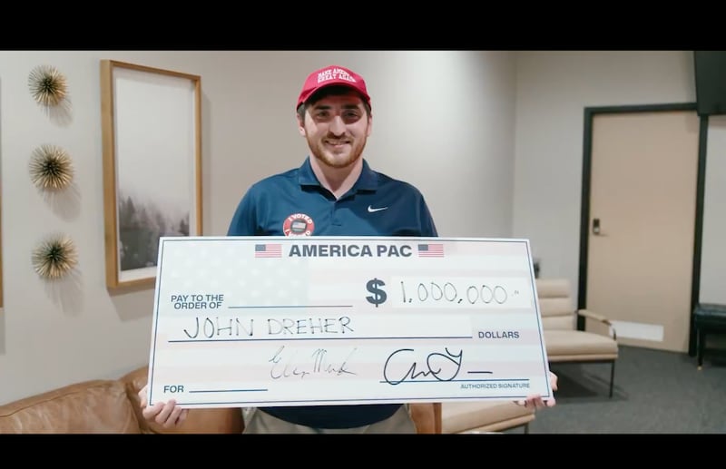 John Dreher holds up a one million dollar vanity check from America PAC.