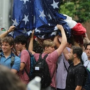 Members of the Pi Kappa Phi fraternity at UNC-Chapel Hill raise the US flag during a pro-Palestinian protest on campus.