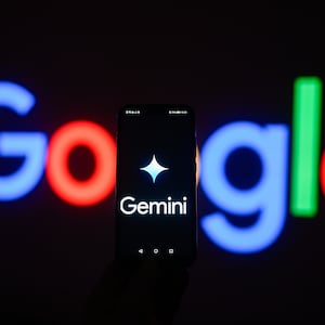 In this photo illustration a Google gemini logo is displayed on a smartphone with stock market percentages in the background. 