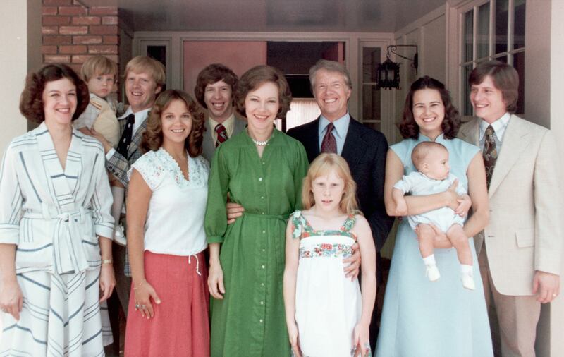 A portrait of President Jimmy Carter and his extended family. Left to right: Judy (Mrs. Jack Carter); Jason James Carter; Jack (John William Carter); Annette (Mrs. Jeff Carter); Jeff (Donnel Jeffrey Carter); First Lady Rosalynn Carter; daughter Amy Lynn Carter; President Carter; daughter-in law Caron Griffin Carter holding James Earl Carter IV; and son Chip (James Earl Carter III). 1977-1980. | Location: outdoors. (Photo by ? CORBIS/Corbis via Getty Images)