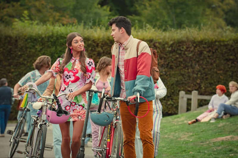 Mimi Keene as Ruby and Asa Butterfield as Otis in Sex Education  walking bikes