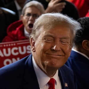 Donald Trump smiles with his eyes closed at an Iowa campaign event.