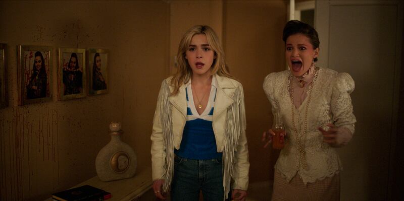 Kiernan Shipka as Jamie Hughes, Olivia Holt as Teen Pam in Totally Killer.