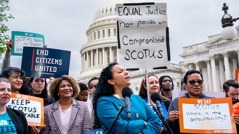 Analilia Mejia of the Center for Popular Democracy, center, joins other activists calling for ethics reform in the U.S. Supreme Court