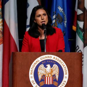 Former president Donald Trump listens as Tulsi Gabbard speaks at a meeting of the National Guard Association in Detroit, Michigan on August 26, 2024