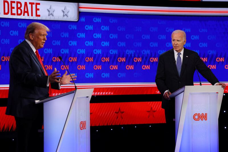 Joe Biden listens as Republican presidential candidate and former U.S. President Donald Trump speaks during their debate in Atlanta, Georgia, U.S., June 27, 2024.