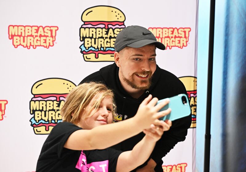 MrBeast poses with fan at the launch of the first physical MrBeast Burger Restaurant at American Dream on September 4, 2022  