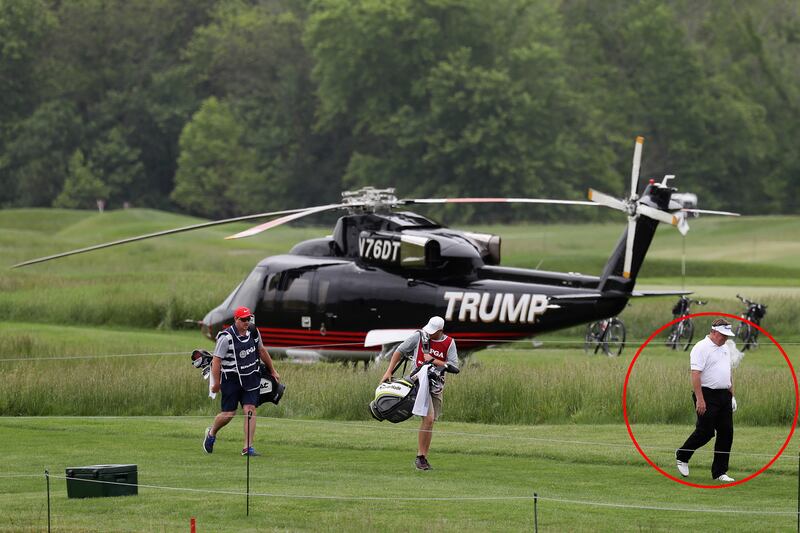 John Nieporte walks past a Trump branded helicopter