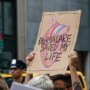 Participants hold signs while protesting the repeal and replacement of the Affordable Care Act. 