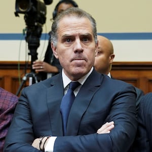 Hunter Biden, wearing a suit and tie, crosses his arm during a hearing.