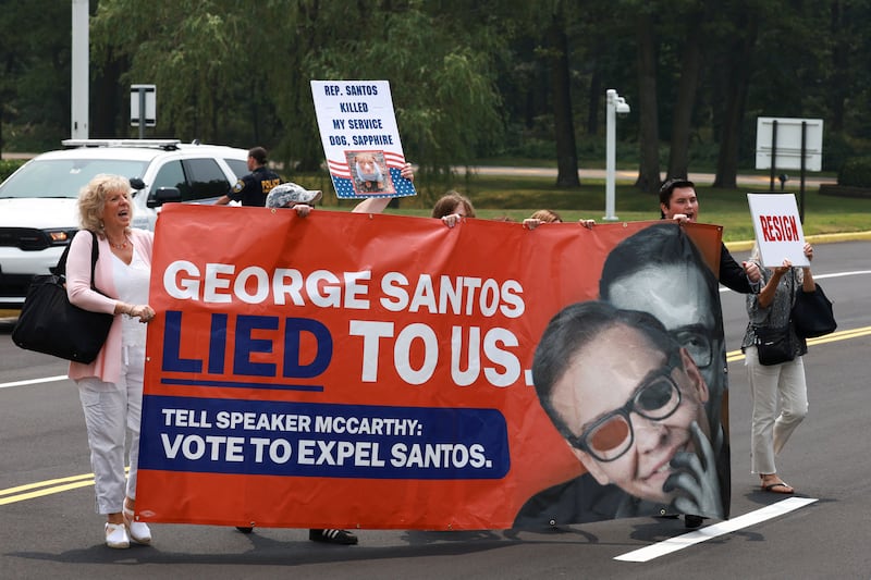 An anti-George Santos protest, with people holding a sign reading, “George Santos Lied to Us.”