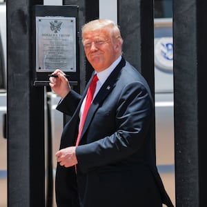 President Donald Trump smiles as he prepares to autograph a plaque commemorating the construction of the 200th mile of border wall while visiting the wall on the U.S.-Mexico border in San Luis, Arizona, U.S., June 23, 2020