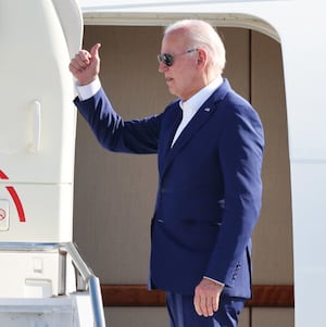 U.S. President Joe Biden gives members of his staff a thumbs up as he boards Air Force One.