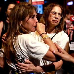 People in Tel Aviv cry and hold signs of hostages held by Hamas in Gaza