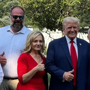 Donald Trump smiles with the loved ones of a fallen marine.