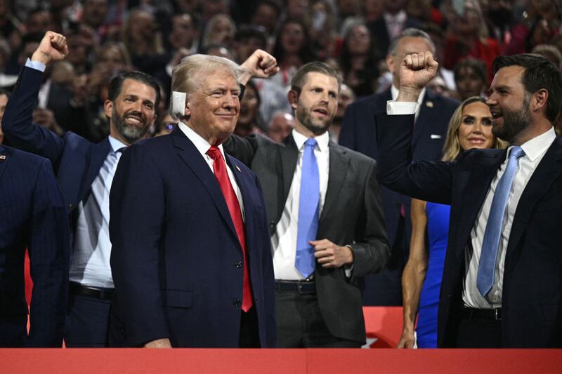 Donald Trump smiles as he is cheered on by his running mate J.D. Vance and his sons Donald Trump Jr. and Eric Trump during the first day of the 2024 Republican National Convention in Milwaukee.