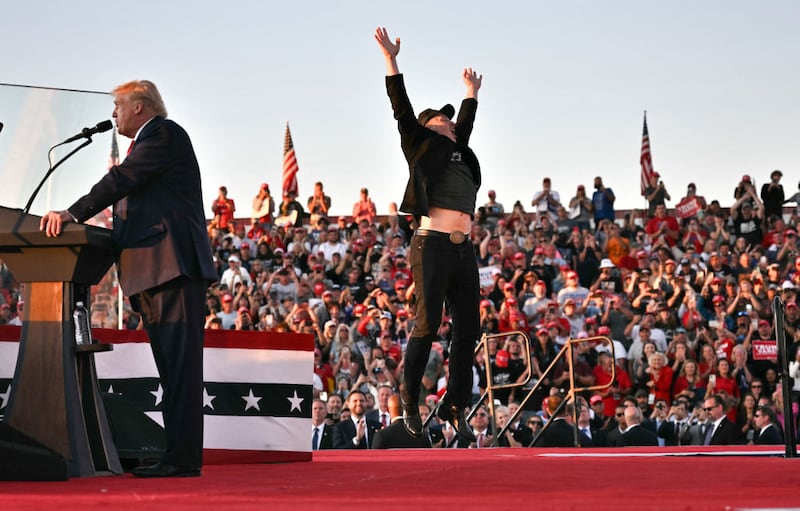 Tesla CEO Elon Musk jumps on stage as he joins former US President and Republican presidential candidate Donald Trump during a campaign rally at site of his first assassination attempt in Butler, Pennsylvania on October 5, 2024.