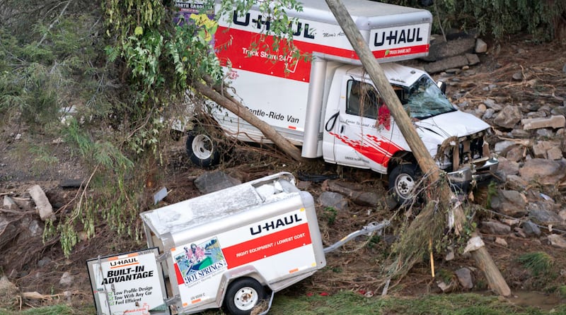 A wrecked U-Haul truck and trailer.