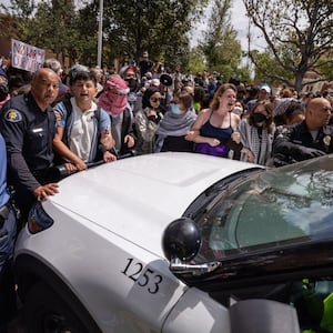 Pro-Palestinian demonstrators shout “Let him go!” after police took a man into custody at the University of Southern California on Wednesday.