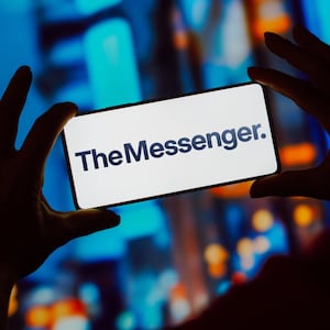 The Messenger is displayed on a phone screen with city lights in the background.