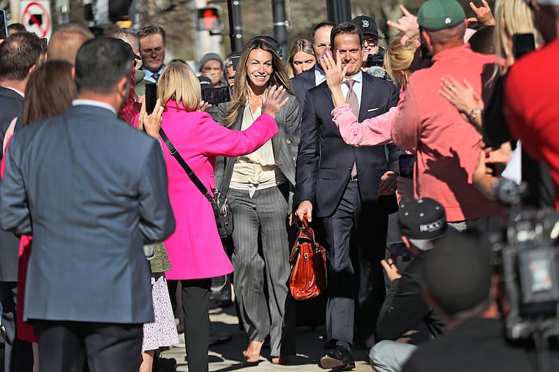 Karen Read walks amongst a crowd to enter a court house. 