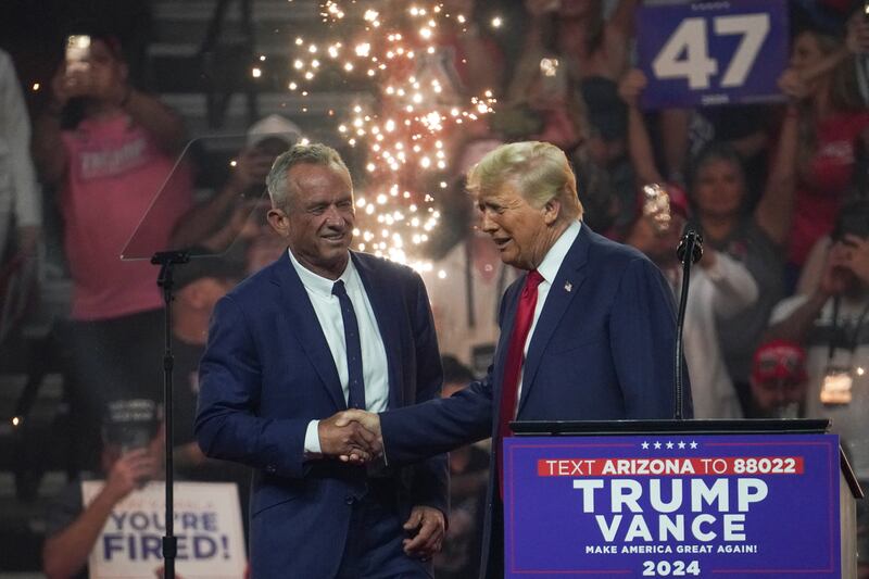 Republican presidential nominee Donald Trump shakes hands with former independent presidential candidate Robert F. Kennedy Jr. during a rally in Arizona.