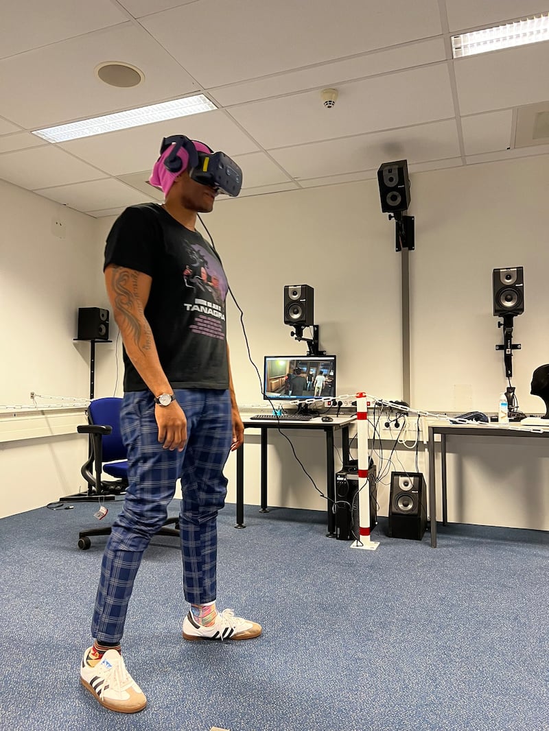 Zeus Tipado stands wearing a VR headset.