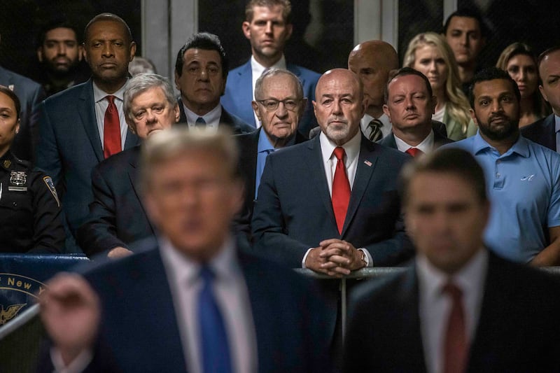 Kash Patel, back right in blue, looks on as Trump speaks during his Manhattan hush money trial, May 20, 2024.