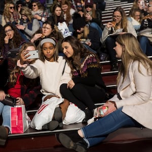 A group of teens take a photograph with a smartphone in Times Square, December 1, 2017 in New York City