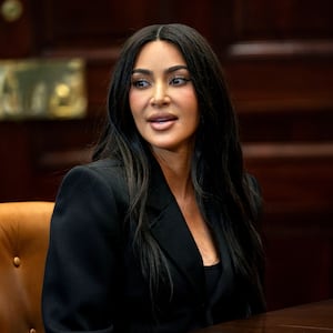 Kim Kardashian, wearing black, speaks at a meeting table.