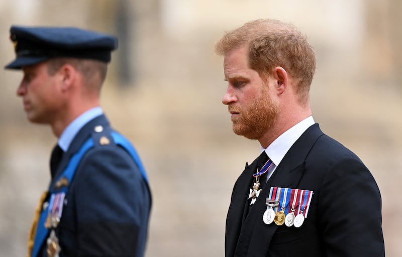 Prince Harry in front of Prince William who is wearing military uniform