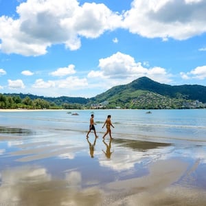 Tourists walk on a beach on the Thai island of Phuket on November 1, 2021.