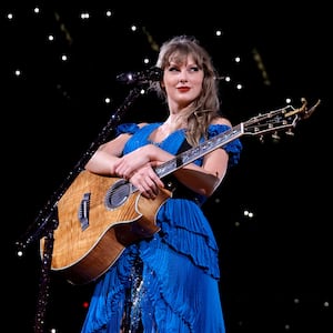 Taylor Swift holding a guitar during the Eras Tour “Surprise Songs” section.