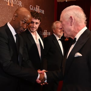 LONDON, ENGLAND - NOVEMBER 13: Pedro Pascal looks on as Denzel Washington meets King Charles III as they attend the Royal Film Performance and Global Premiere of "Gladiator II" in Leicester Square on November 13, 2024 in London, England. (Photo by Eddie Mulholland - WPA Pool/Getty Images)