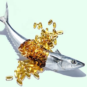 image of thin silver fish broken in half with overflow of yellow pills from stomach oil amarin corp vascepa fda heart disease stroke attack