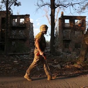 A Ukrainian serviceman of the 225th Separate Assault Battalion patrols as he walks past an apartment building destroyed by an airstrike in the town of Chasiv Yar, Donetsk region, on July 24, 2024, amid the Russian invasion of Ukraine. 